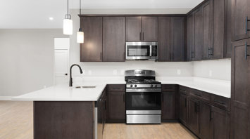 Monte View at Pohatcong Gourmet kitchen with peninsula, quartz countertops, and stainless steel appliances in luxury garden apartment for rent in Pohatcong Twp, NJ – Monte View at Pohatcong