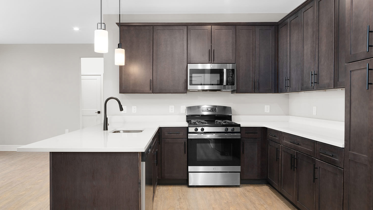 Monte View at Pohatcong Gourmet kitchen with peninsula, quartz countertops, and stainless steel appliances in luxury garden apartment for rent in Pohatcong Twp, NJ – Monte View at Pohatcong