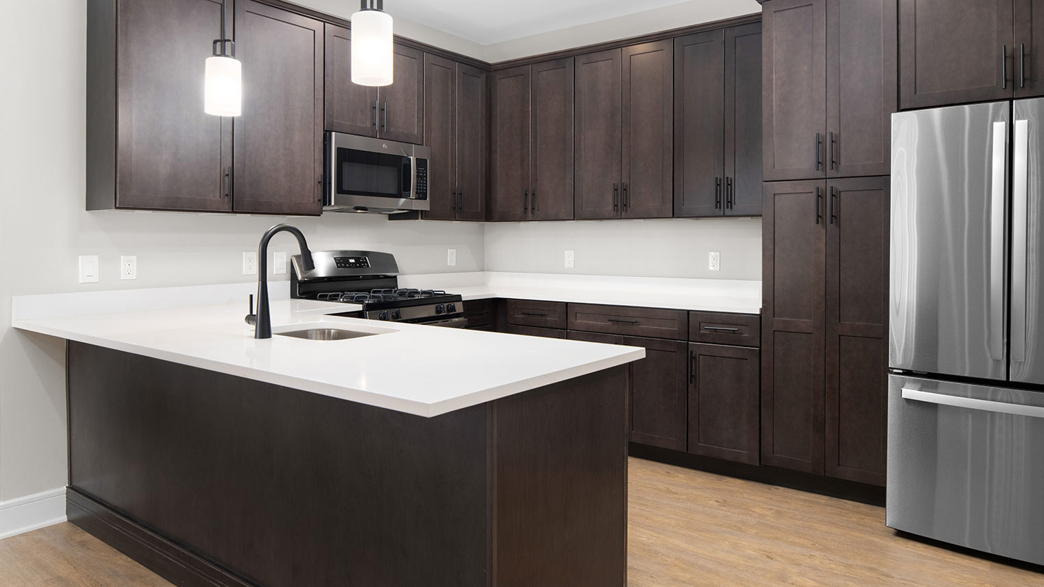 Monte View at Pohatcong Luxury garden apartment kitchen with a peninsula, quartz countertops, and stainless steel appliances in Pohatcong Twp, NJ – Monte View at Pohatcong