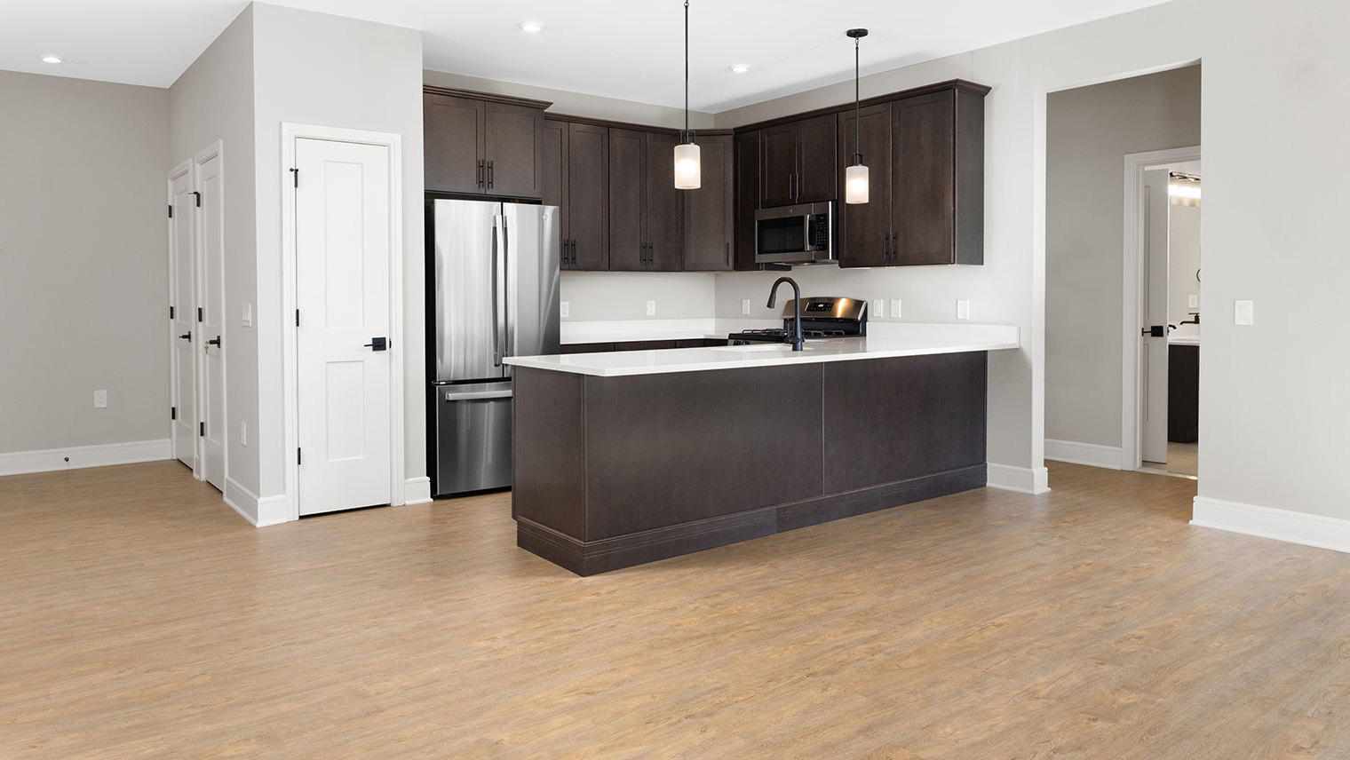 Monte View at Pohatcong Luxury Atmore model garden apartment kitchen with a peninsula, quartz countertops, and stainless steel appliances in Pohatcong Twp, NJ – Monte View at Pohatcong
